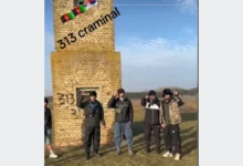 مجموعة أشخاص يقفون أمام مبنى حجري وتظهر على الصورة عبارة 313 criminal وأعلام أفغانستان