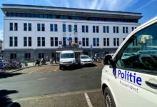 سيارات شرطة بروكسل الغربية أمام مبنى رسمي مع ظهور شعار Politie Brussel-West على إحدى المركبات