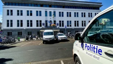 سيارات شرطة بروكسل الغربية أمام مبنى رسمي مع ظهور شعار Politie Brussel-West على إحدى المركبات