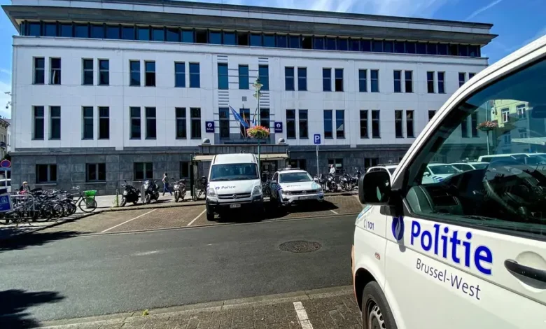 سيارات شرطة بروكسل الغربية أمام مبنى رسمي مع ظهور شعار Politie Brussel-West على إحدى المركبات
