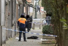 عنصر من الشرطة البلجيكية داخل منطقة طوق أمني في شارع شهد حادث إطلاق نار