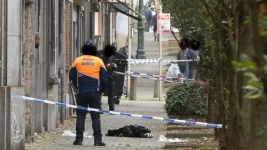 عنصر من الشرطة البلجيكية داخل منطقة طوق أمني في شارع شهد حادث إطلاق نار