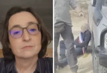 امرأة ترتدي نظارات طبية وبجانبها مشهد لشخص على الأرض قرب سيارة خلال حادثة مصورة