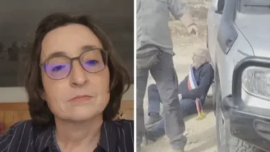 امرأة ترتدي نظارات طبية وبجانبها مشهد لشخص على الأرض قرب سيارة خلال حادثة مصورة